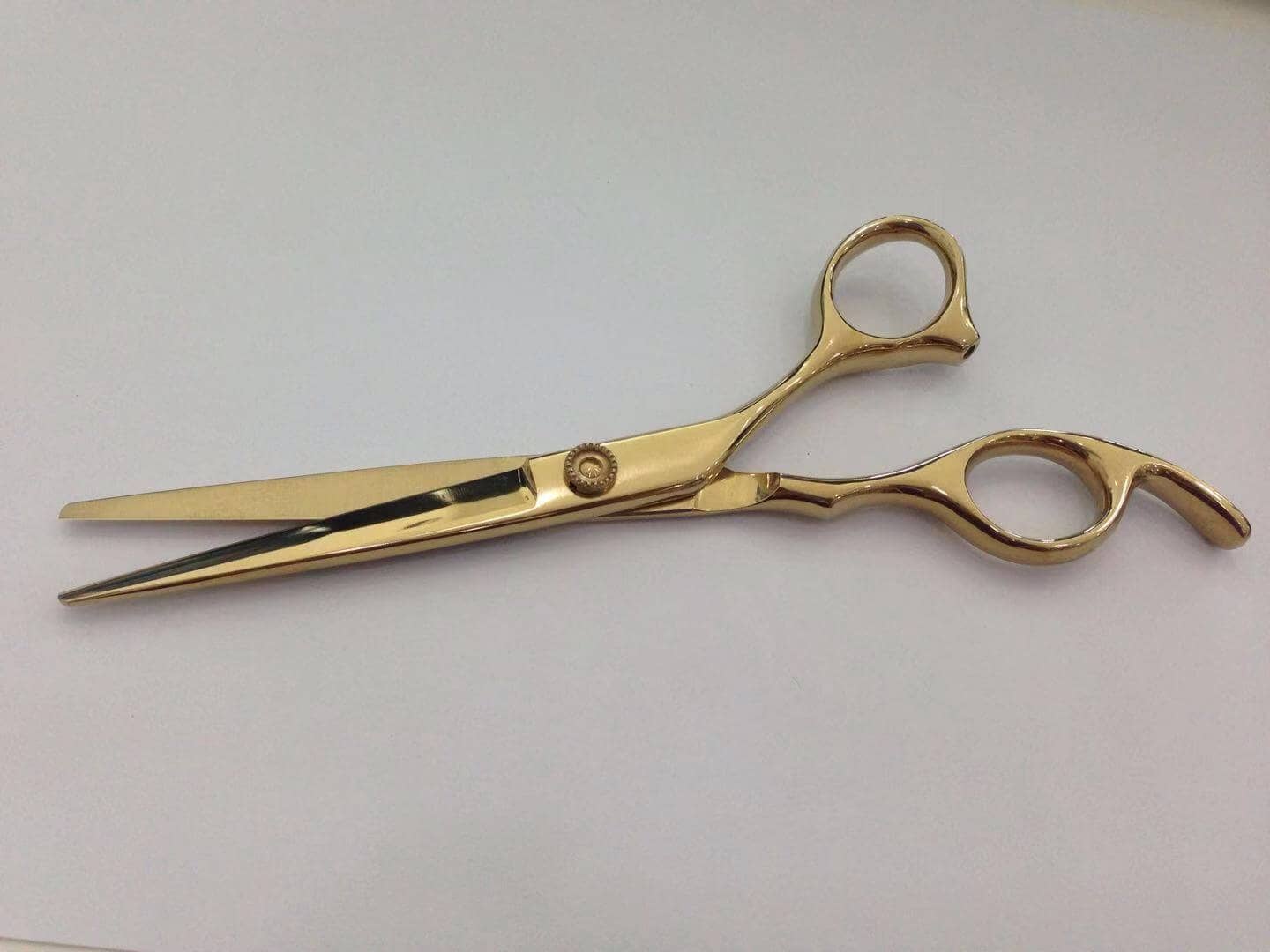 Barber scissor in pvd titanium gold color.